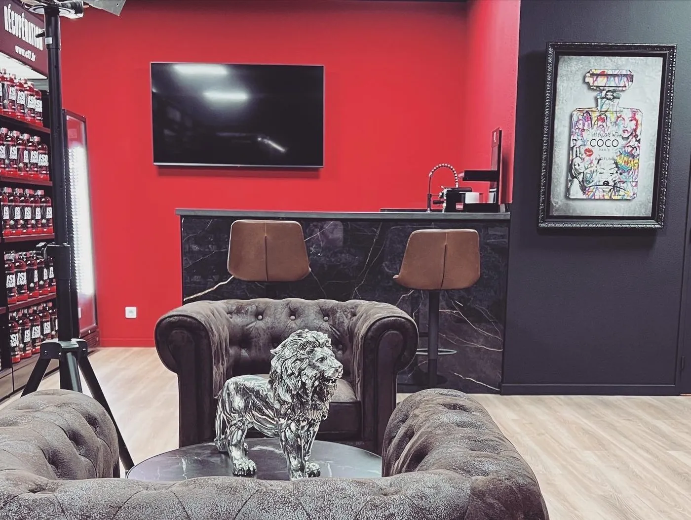 L’accueil d’un centre CF7 : mur rouge, fauteuils Chesterfield, lion argenté et rayons de compléments.