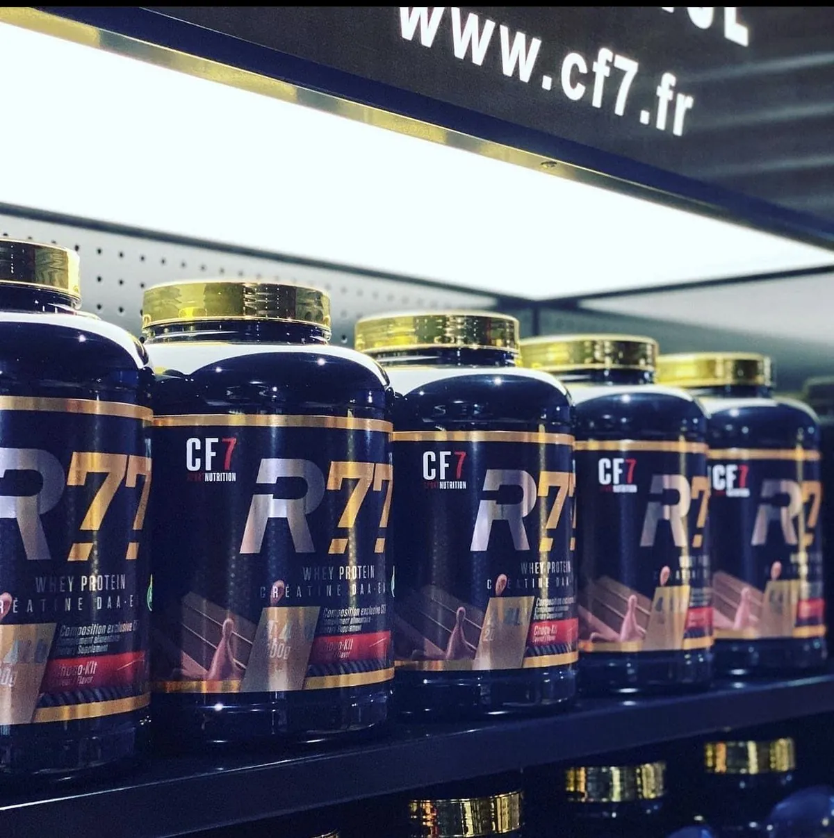 Des pots de protéine CF7 R77 alignés sur un rayon, sous l’adresse cf7.fr.